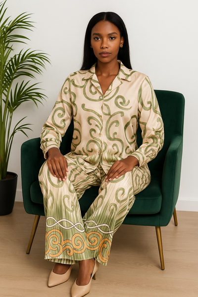Femme assise portant un ensemble en satin beige imprimé vert et orange, gros plan sur la chemise fluide.