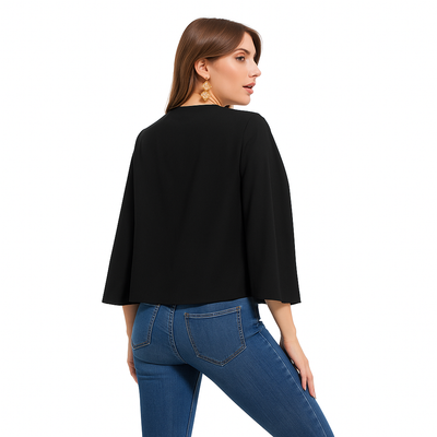 Femme élégante vue de dos en blazer cape noir, style sophistiqué.