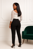 Vue arrière d’un combi-pantalon noir avec haut en dentelle blanche et fermeture discrète.