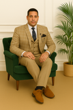 Costume trois pièces beige à carreaux – homme assis avec allure élégante sur fauteuil vert