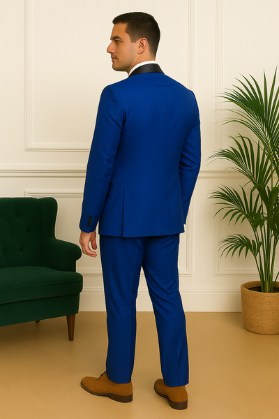 Vue de dos d’un costume bleu roi coupe droite avec col satiné noir, fond beige et moulures blanches.