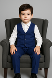 Garçon assis portant un costume bleu royal élégant et moderne.