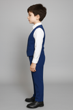 Garçon vu de profil portant un gilet et un pantalon bleu royal.