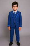 Garçon debout en costume bleu royal avec veste et gilet cérémonie.