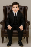 Garçon en costume de cérémonie noir assis sur un fauteuil, look élégant et chic.