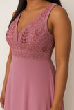 Gros plan sur le haut pailleté et le décolleté en V d’une robe de soirée mauve élégante.