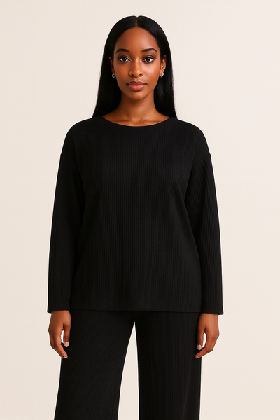 Femme élégante posant avec un ensemble noir en maille côtelée, pantalon large et haut ample.