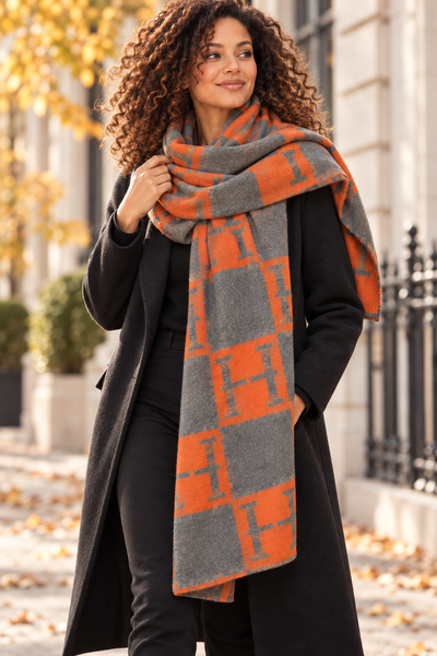 Vue de face d’une femme portant une étole à motifs géométriques gris et orange
