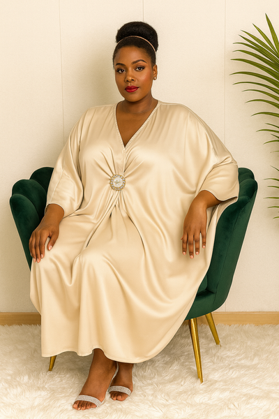 Robe caftan satin beige fluide – détail du décolleté en V et de la broche