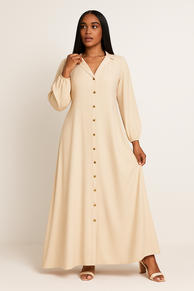 Femme portant une robe longue fluide boutonnée beige, col en V et boutons dorés.