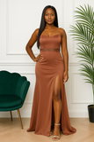: Femme portant une robe de soirée marron bustier avec broderie et fente.