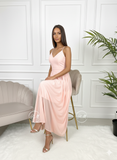 Robe longue de cocktail rose poudré, vue assise élégante.