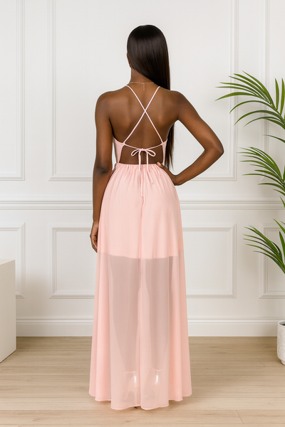 Robe de cocktail longue rose poudré, dos croisé élégant.