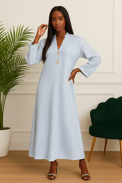 Femme portant une robe longue rayée bleu ciel avec deux boutons dorés, vue de face.