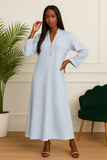 Femme portant une robe longue rayée bleu ciel avec deux boutons dorés, vue de face.