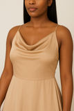 Robe longue satinée camel, gros plan sur le décolleté drapé avec fines bretelles, tissu fluide et élégant.