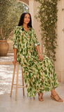 Robe longue verte taille unique portée assise avec des sandales plates