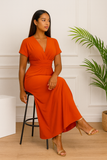 Robe longue multiposition terracotta assise sur tabouret 
