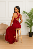 Robe longue multiposition rouge bordeaux assise sur tabouret, dos croisé sensuel