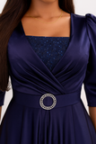 Zoom sur la ceinture bijou scintillante de la robe de soirée longue bleu nuit en satin.