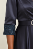 Détail des manches mi-longues de la robe de soirée satin bleu nuit avec sequins et dentelle.