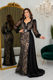 Femme portant une robe de soirée longue sirène noire et beige brodée, avec manches bouffantes